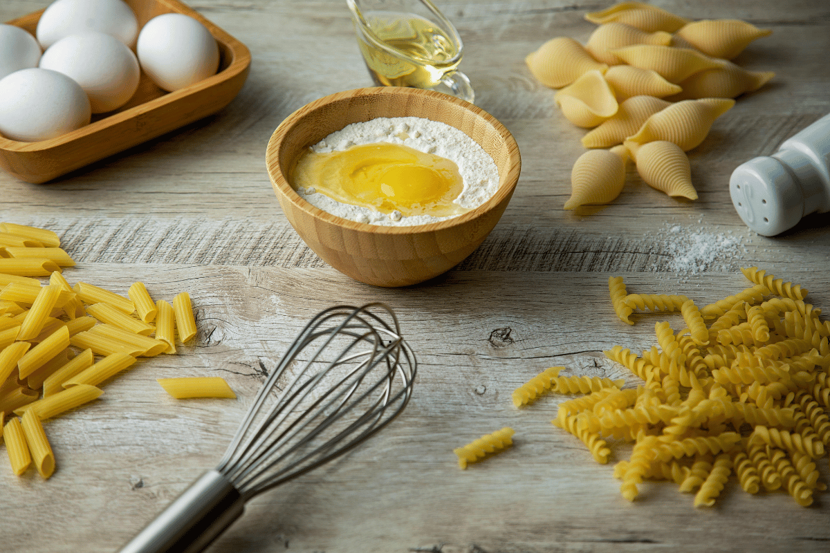 Ingredients for Marry Me Chicken Pasta including chicken, Parmesan cheese, pasta, garlic, and sun-dried tomatoes