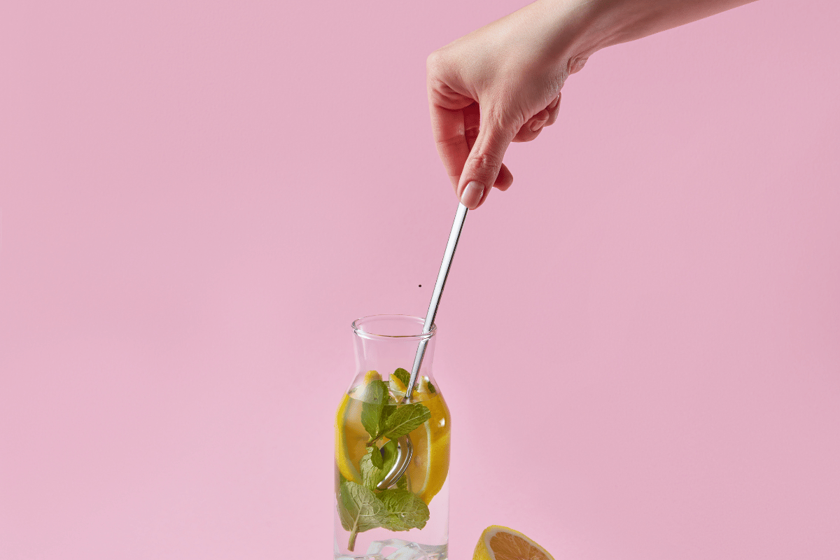Mixing homemade lemonade with lemon slices and ice