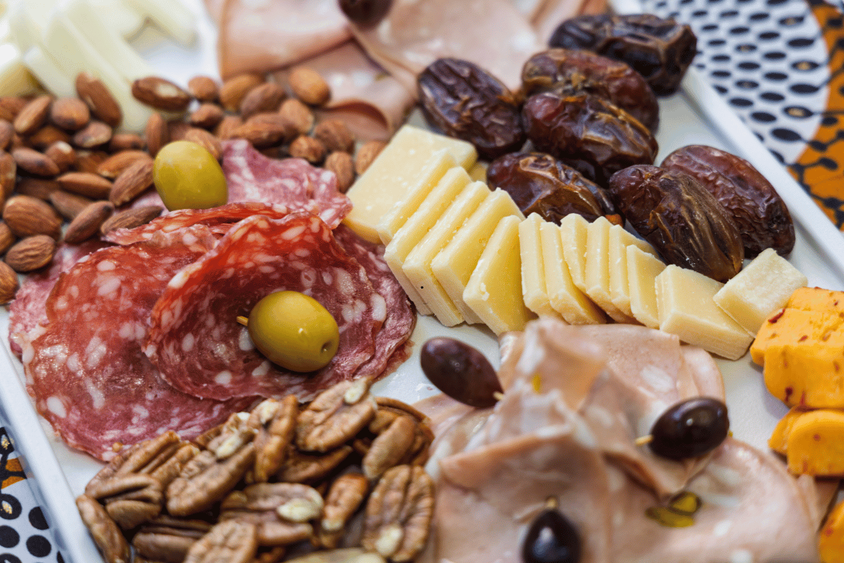 Charcuterie dinner board with cheese, fruit, crackers, and deli meats