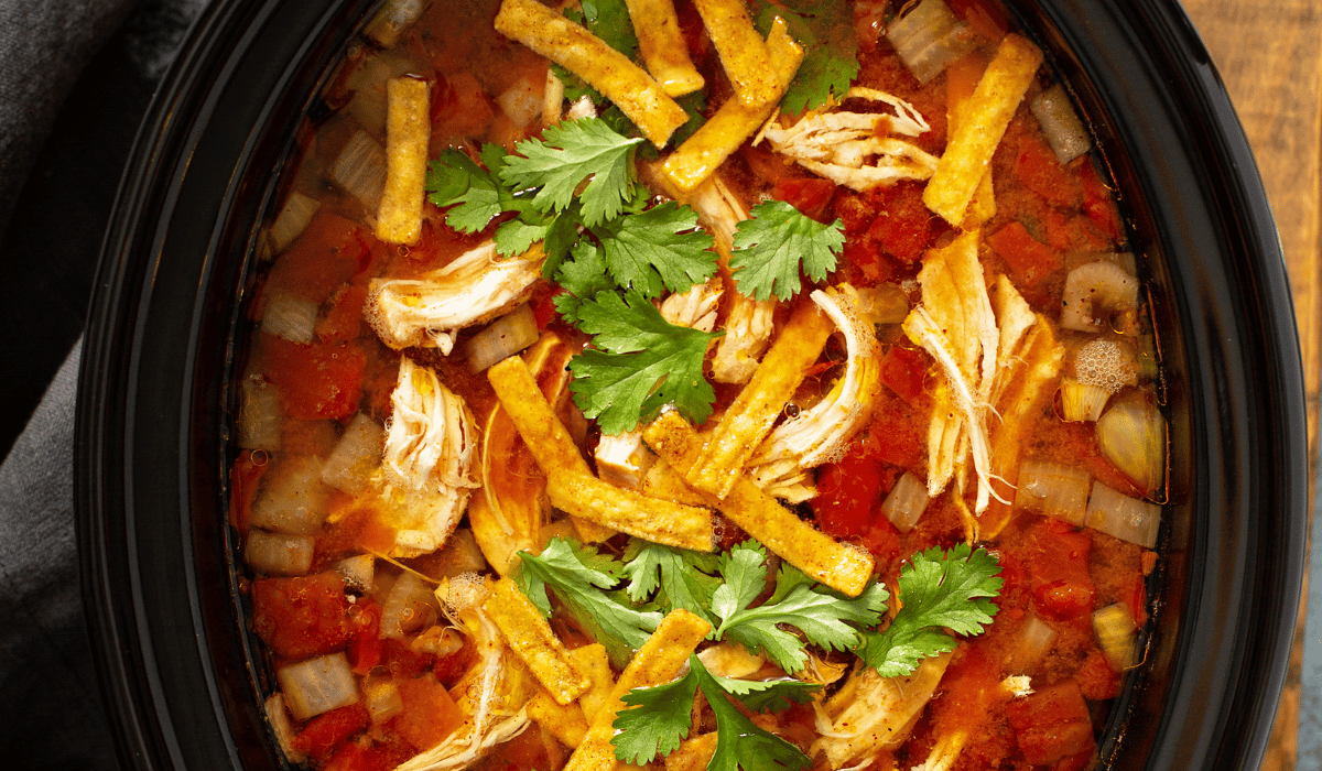 Shredded chicken cooking with salsa in a crockpot