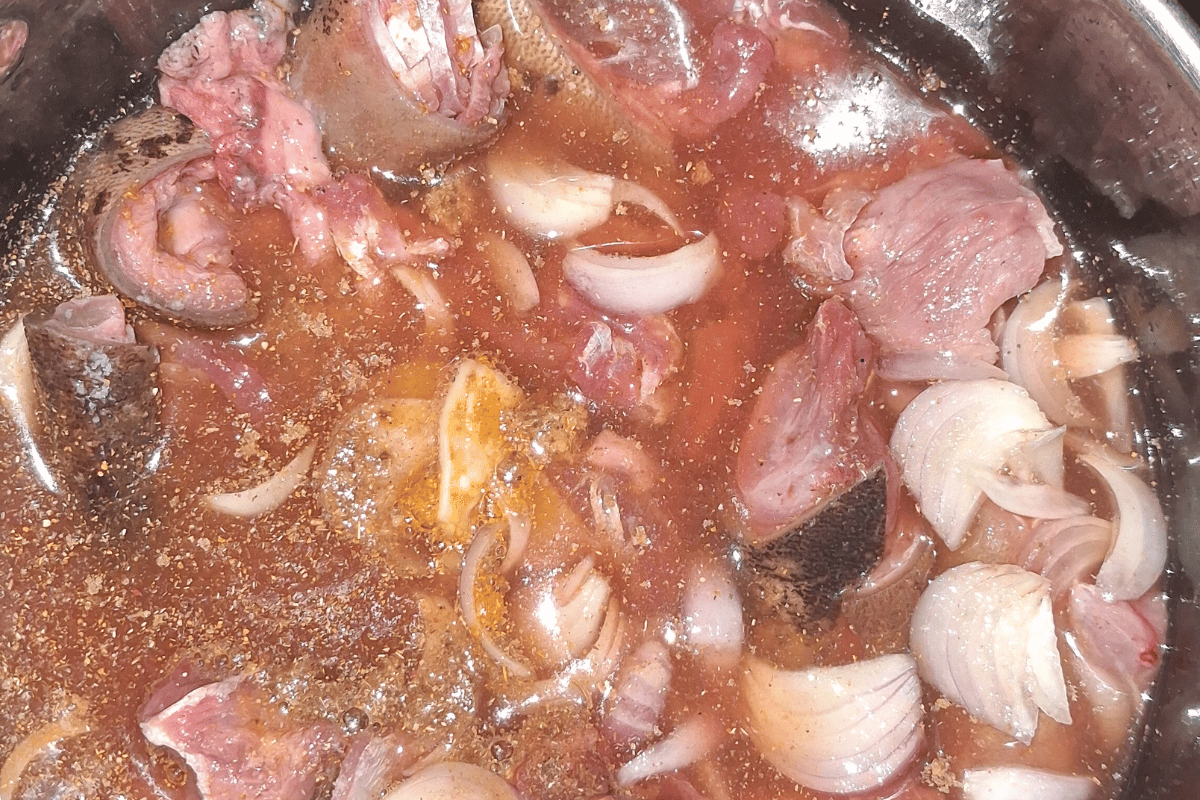 Goat meat steaming with reserved tomato water for a budget-friendly Nigerian fresh tomato stew recipe.